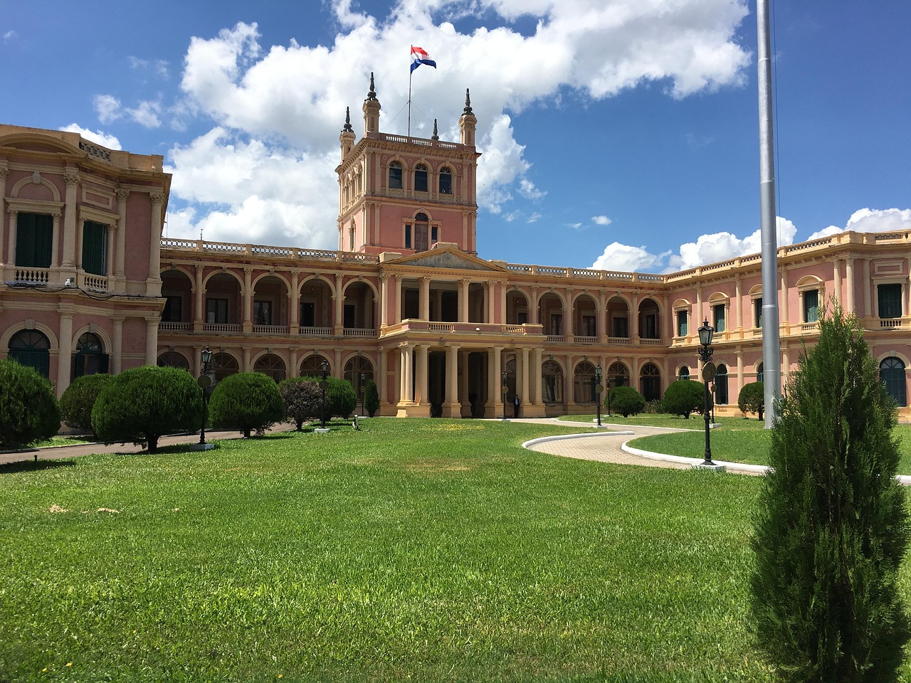 A wide view of the Palacio de los López, the presidential palace in Asunción, under a bright blue sky with scattered clouds.